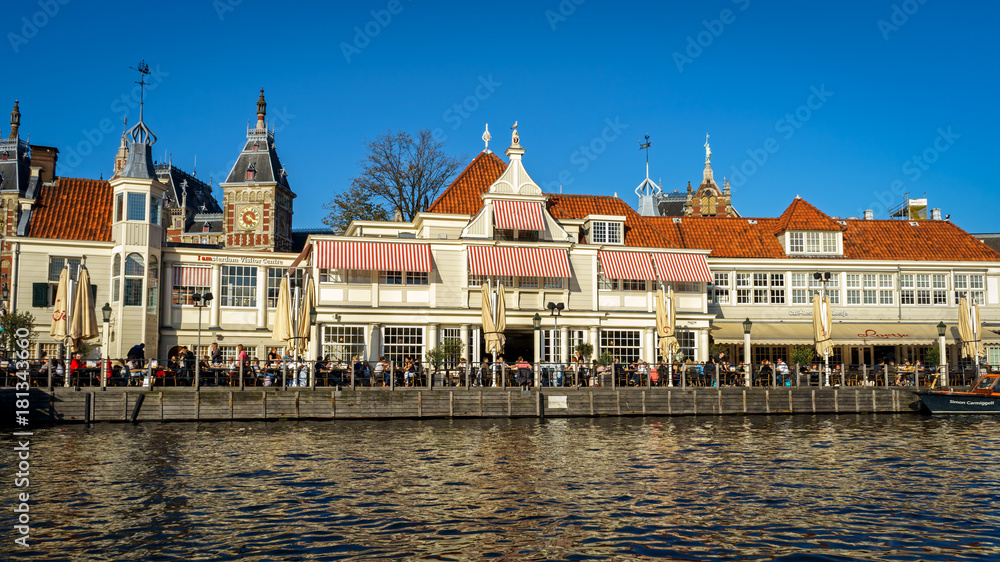 Fototapeta premium People sitting in Cafe restaurant on the canal in Amsterdam, the Netherlands, October 13, 2017