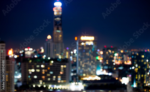 Colorful of city modern buildings night abstract background, decorated with de-focus bokeh lights cities offices of reflecting building in Bangkok Thailand.