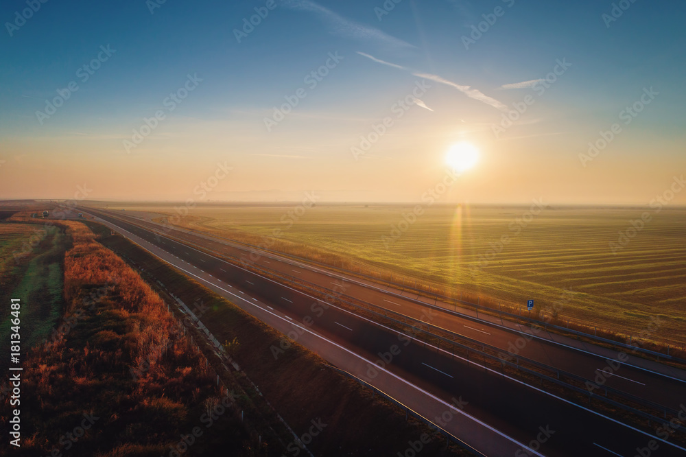 Aerial view of highway with forest and fields in fog