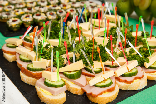 bruschetti or canapes with cheese, olives, ham, cucumber photo