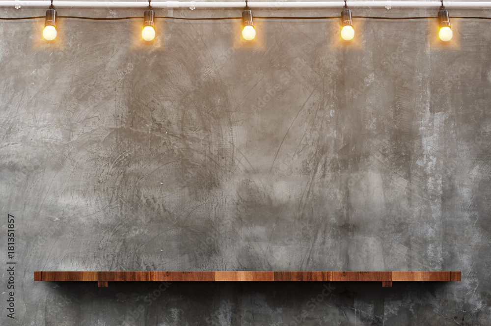 Empty brown wood plank board shelf at grunge concrete wall with light bulb string party background,Mock up for display or montage of product or design