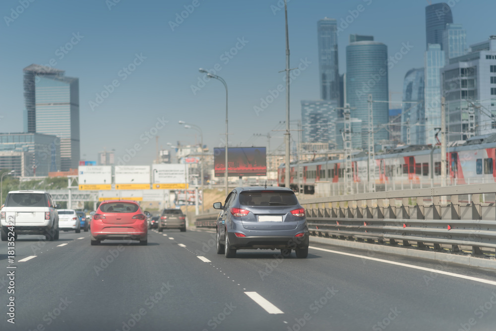 Naklejka premium Skyscraper road with many cars. Traffic on a city road