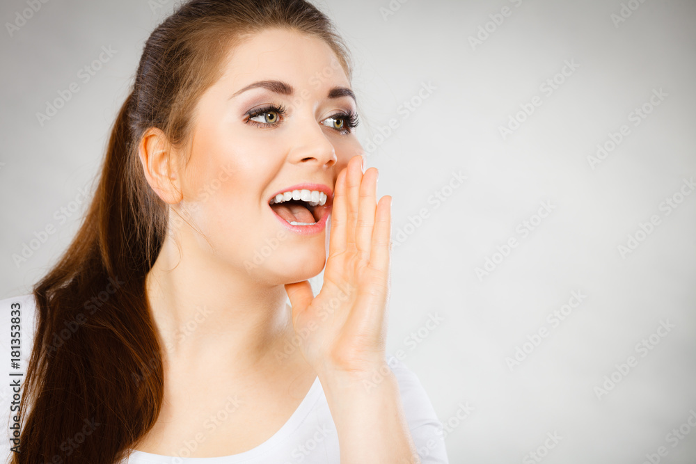 Woman talking gossip with hand close to lips Woman talking gossip with hand close to lips