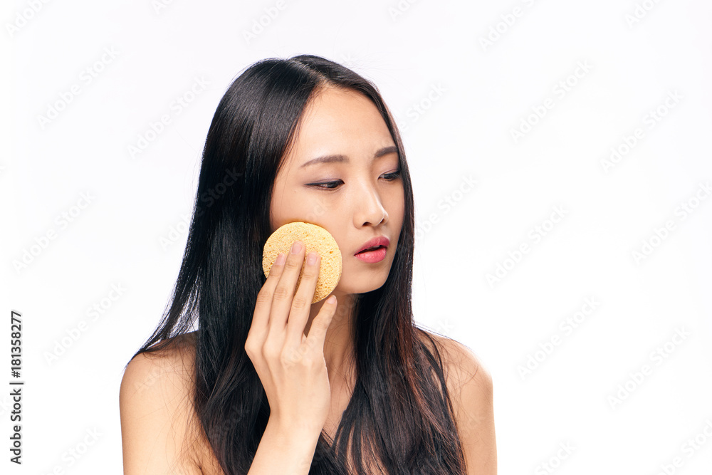 Asian woman on white isolated background washes cosmetics makeup remover Asian woman on white isolated background washes cosmetics makeup remover