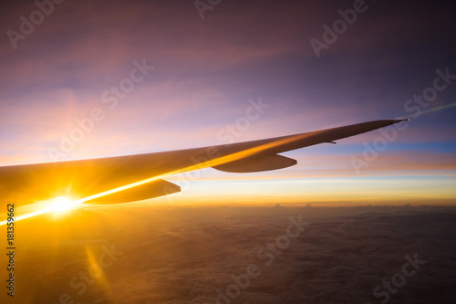 View of beautiful sunrise and flare outside airplane window