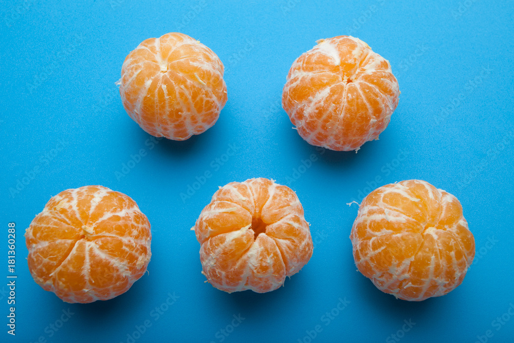 Orange mandirins without peel on a blue background. Orange mandirins without peel on a blue background.
