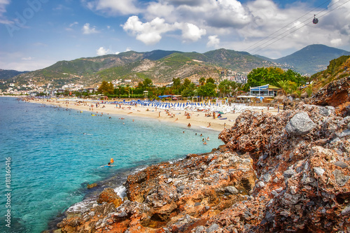 Fototapeta Naklejka Na Ścianę i Meble -  Paradise tropical resort beach in Alanya, Turkey. Sea and rocky mountains on turkish beach on summer sunny day with clouds. Summer relax vacation.