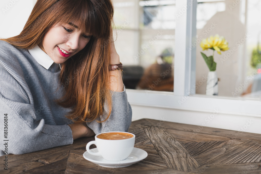 woman sit in cafe with hot cappuccino coffee on wood table during brunch. asian female have a break in coffee shop. woman sit in cafe with hot cappuccino coffee on wood table during brunch. asian female have a break in coffee shop.