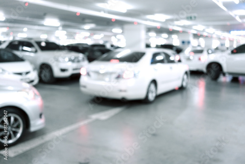 Blured image of Many cars in parking garage interior, industrial building