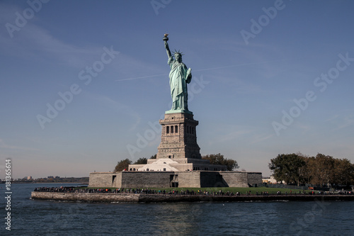 Freiheitsstatue vom Boot mit Insel, mit blauem Himmel, New York © c-foto