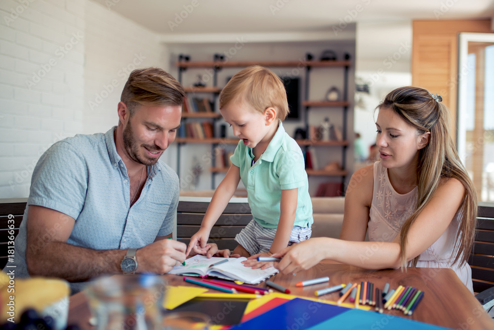 Fototapeta premium Mother and father drawing together with their child