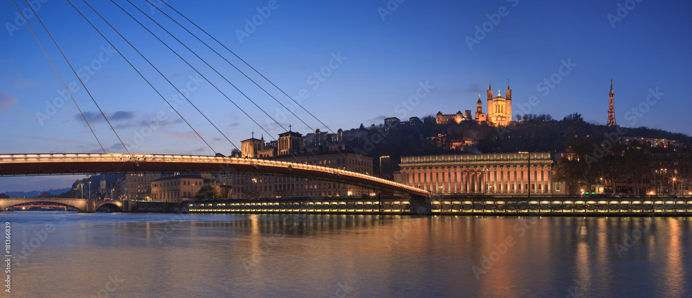 Panorama of footbridge ’Passerelle Palais du Justice’ over the Saone river in Lyon during twilight.