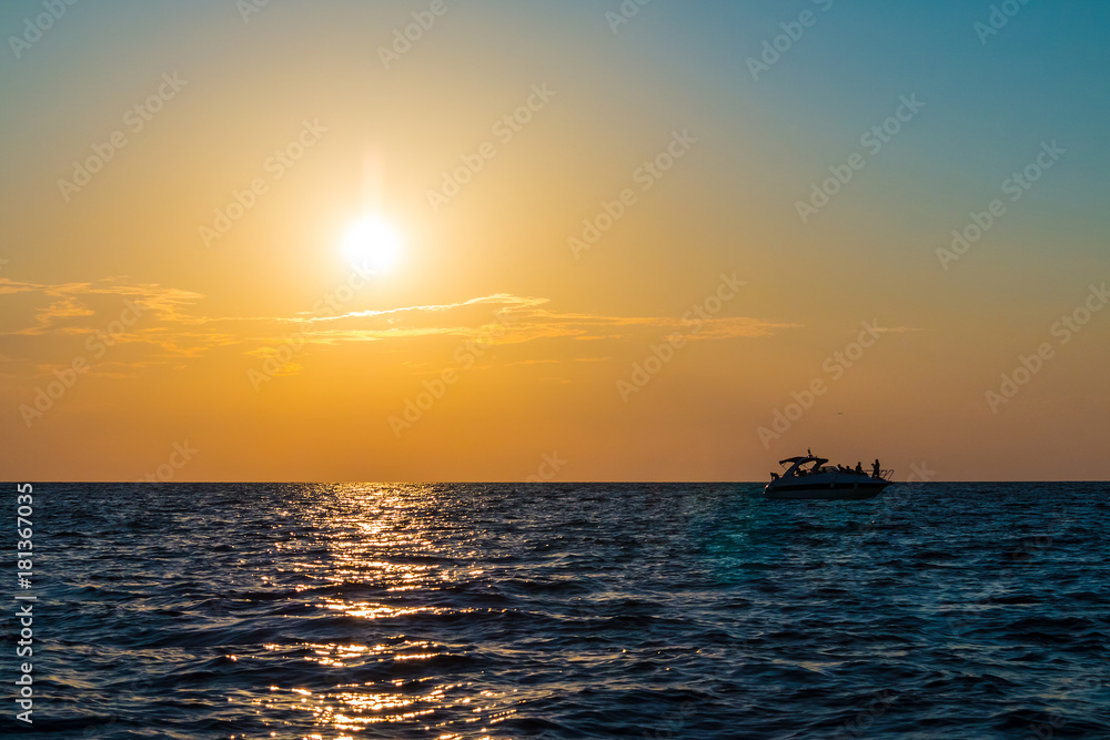 The setting sun over the sea and the motorboat sailing in the distance
The setting sun over the sea and the motorboat sailing in the distance