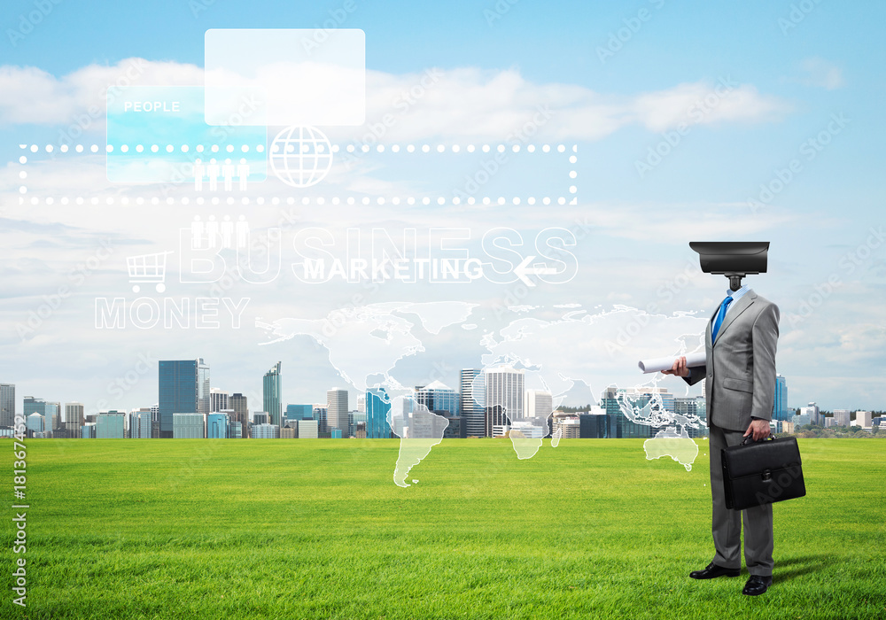 Camera headed man standing on green grass against modern cityscape Camera headed man standing on green grass against modern cityscape
