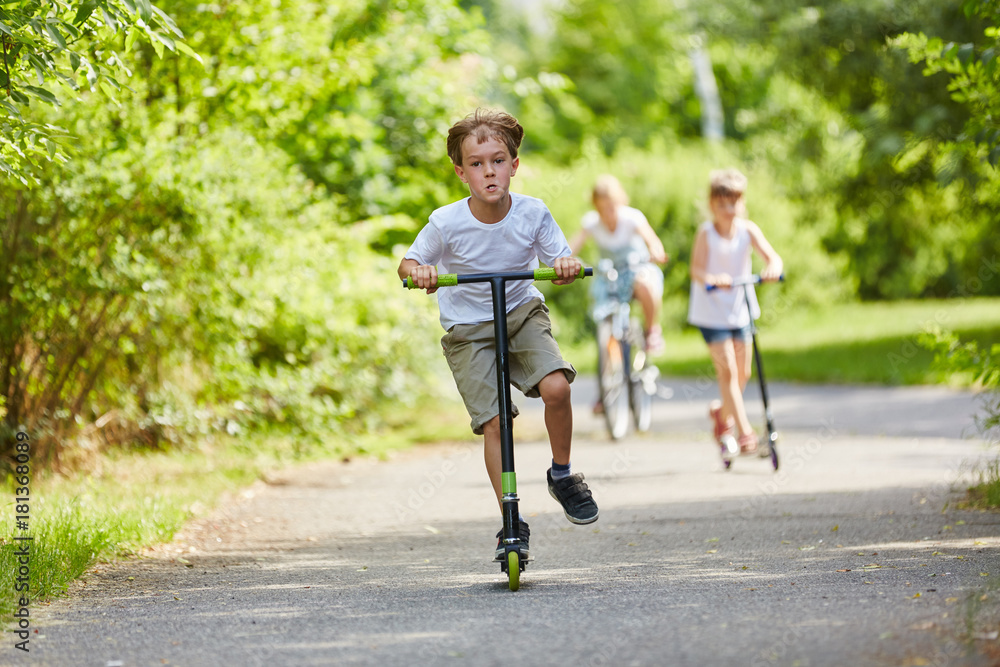Kind Auf Roller Vorne Mitnehmen Strafe Aktive Kinder fahren mit dem Roller Stock Photo | Adobe Stock