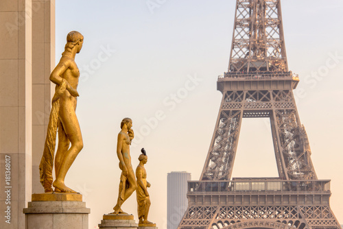 Golden bronze statues on Trocadero square, Eiffel tower in the background, Paris France
