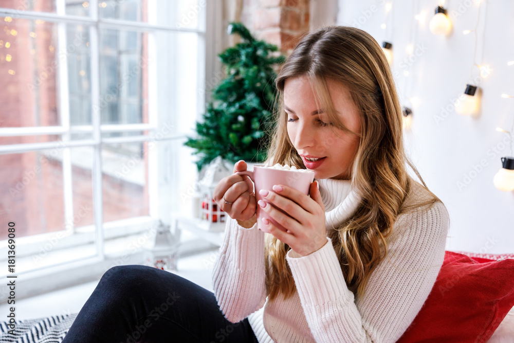 Girl drinks cocoa with marshmallow. Cozy winter morning, New Year's and Christmas holidays Girl drinks cocoa with marshmallow. Cozy winter morning, New Year's and Christmas holidays