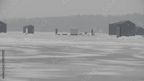 Huts set up for ice fishers and some people outside