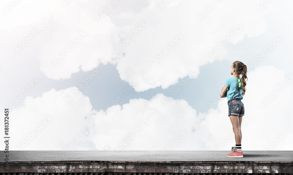 Concept of careless happy childhood with girl looking far away Concept of careless happy childhood with girl looking far away