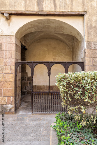 Embedded space with wooden balustrade and wooden arches behind a planted flower box at the external wall of an old historic house (Beit El sehemy), Cairo, Egypt photo