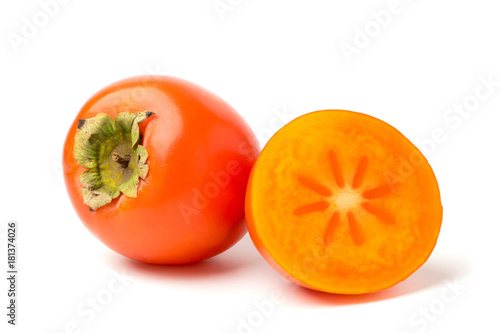 A persimmon, and half on white, closeup. photo