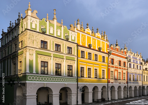 Baroque Armenian tenement houses in Zamość, Poland. Colourful facades against dark blue sky.