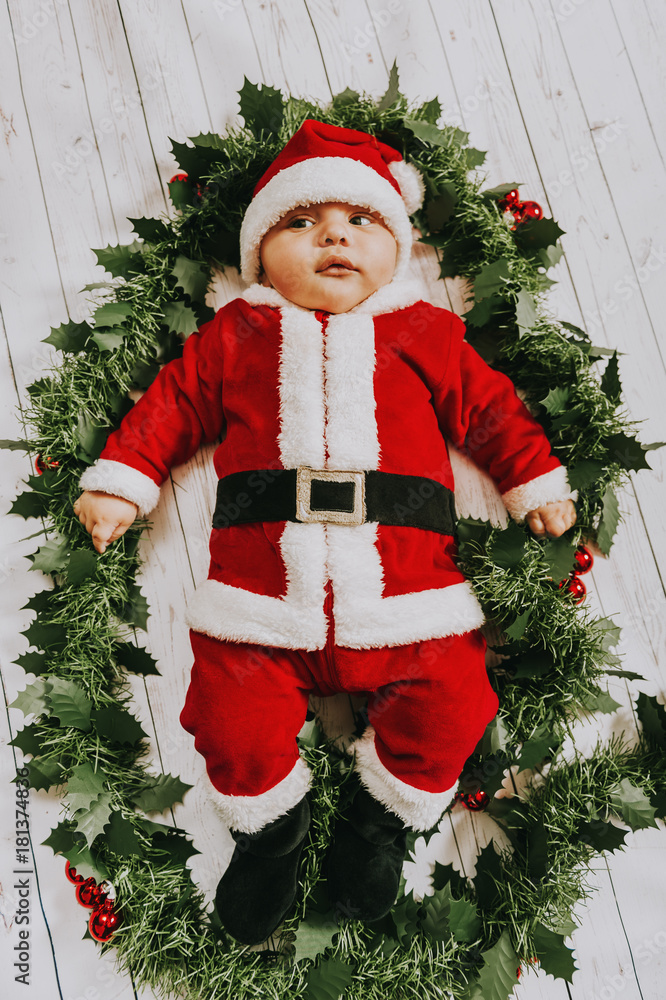 Studio shot of adorable baby boy wearing Santa Claus outfit