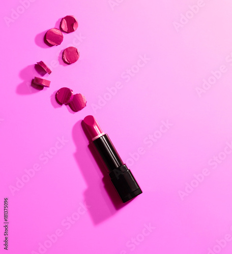 red sliced pieces near lipstick and cap