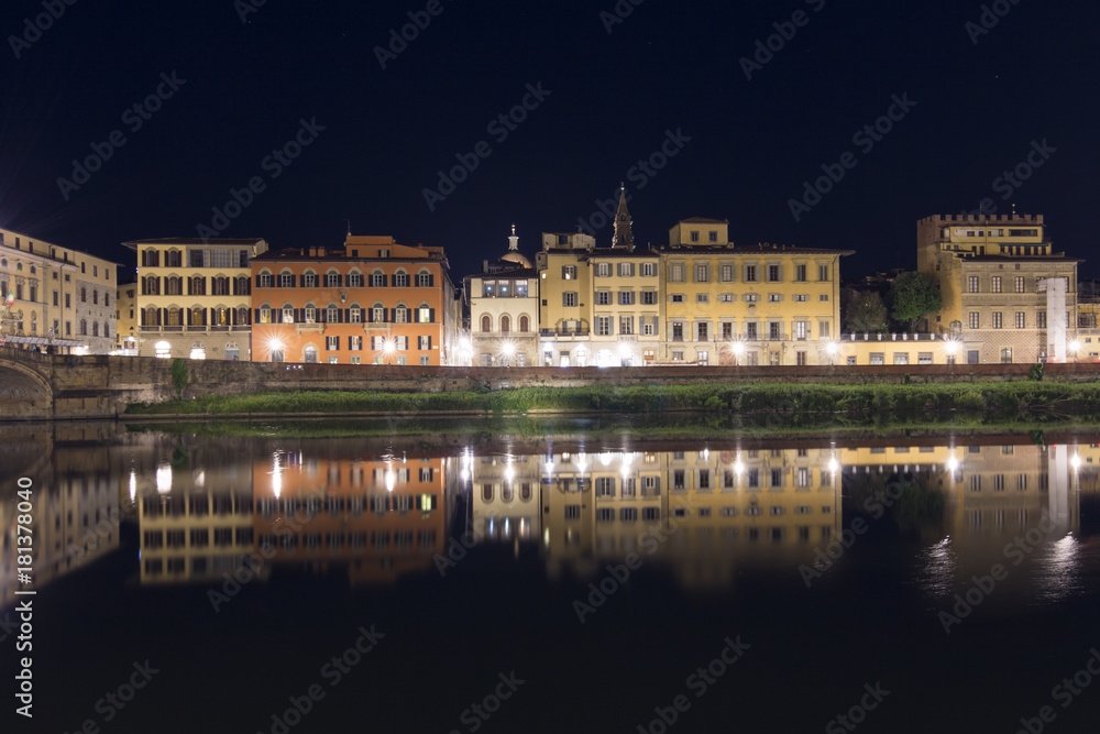 Night shot of typical houses of Florence with its reflection on the river Arno