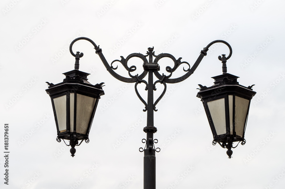 Close up of ornamental street lamp against cloudy gray sky