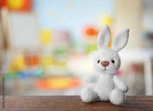 Cute toy and blurred interior of children room on background