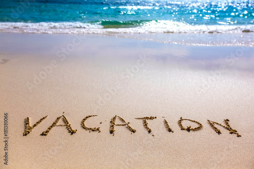 Vacation text on sandy beach