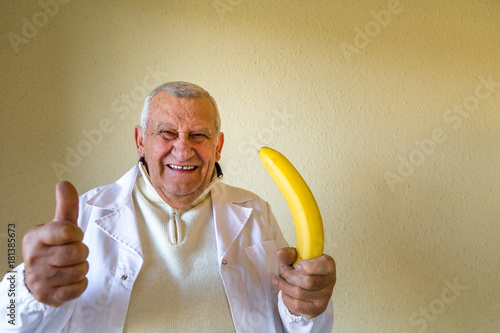 Fotografie doctor holding banana as impotence concept