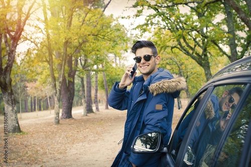 young adult with car and outdoor mobile phone