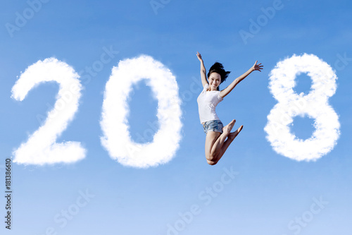 Beautiful woman jumping with numbers 2018