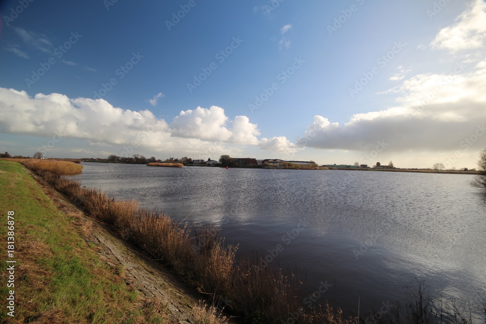Wide angle overview of blue sky, white clouds and river Hollandse IJssel in Moordrecht, Netherlands