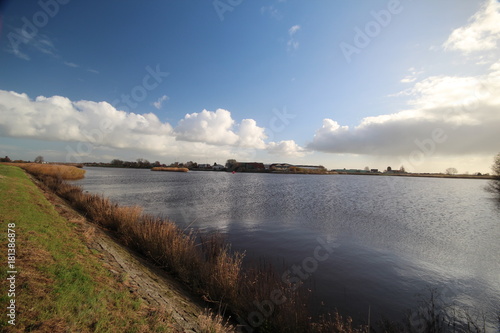 Wide angle overview of blue sky, white clouds and river Hollandse IJssel in Moordrecht, Netherlands