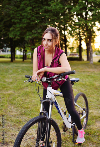 Cute girl riding a bike in the park on a nature background