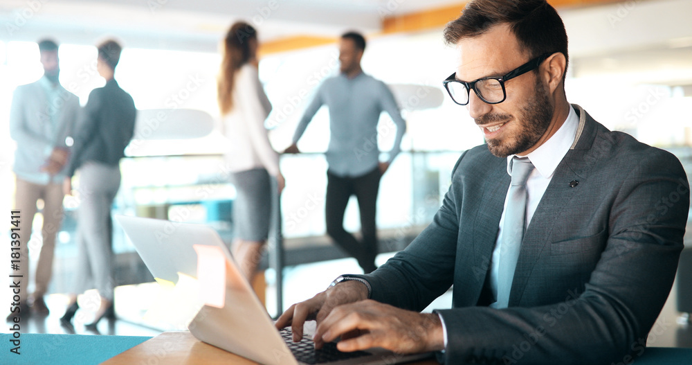 Professional handsome businessman using laptop at workplace Professional handsome businessman using laptop at workplace