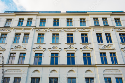 white residential facade with blue windows