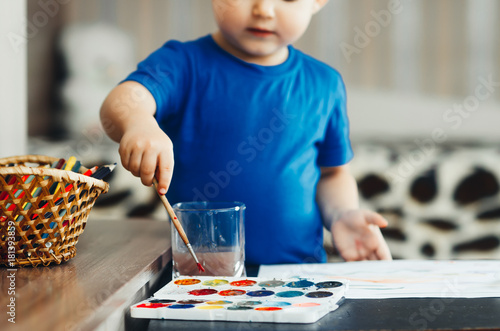 Foto the baby in the nursery, with enthusiasm draws paints