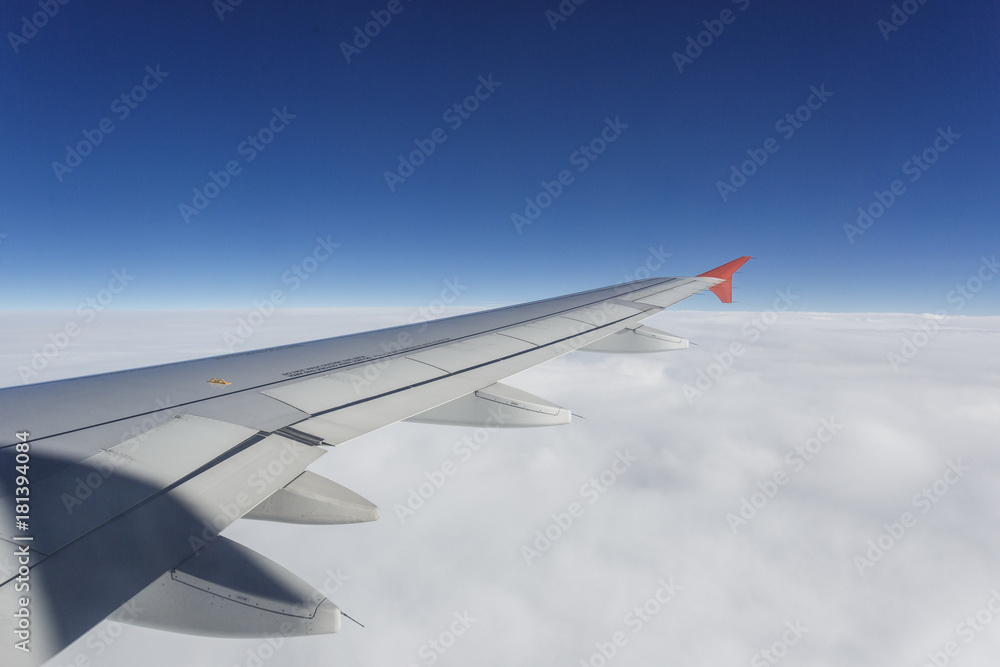 Fototapeta premium cloudy sky with wing of airplane view from illuminator