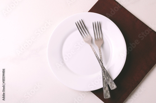 Food background. White empty plate  cutlery  napkin. Top view  copyspace.