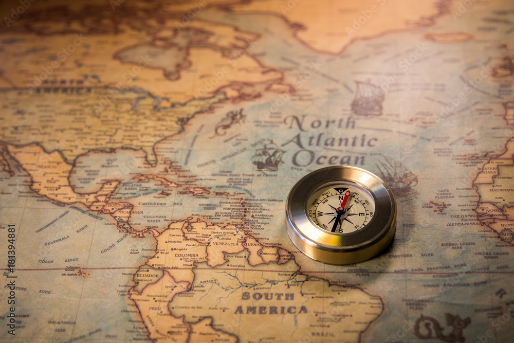 Old vintage retro golden compass on ancient map. Selective focus, shallow depth of field. Concept of world travel, sightseeing and tourism.
