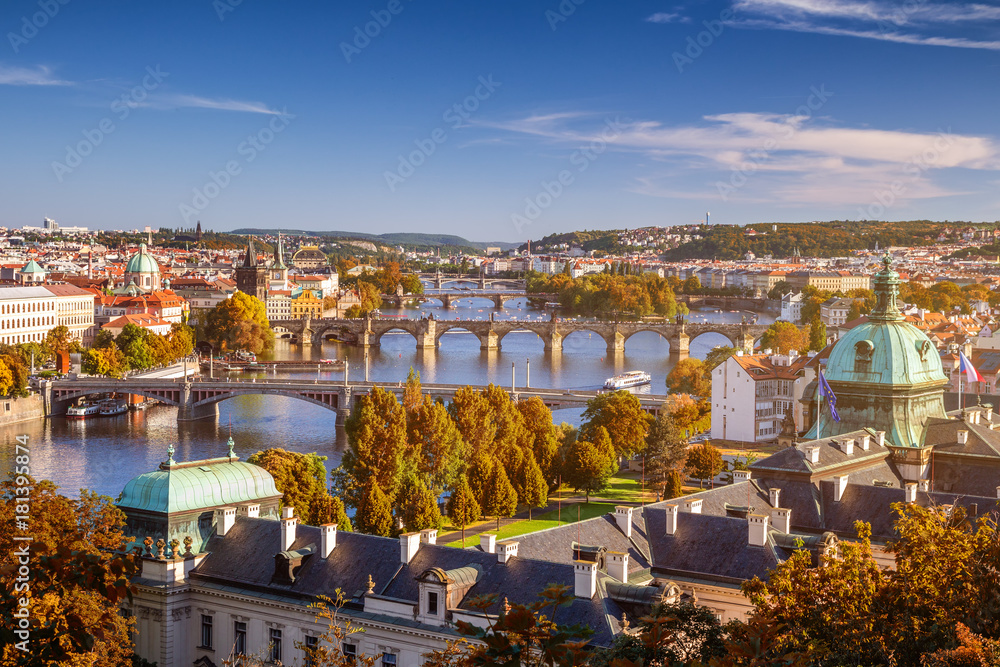 View of the Vltava River and Charle bridge with autumn red foliage, Prague, Czech Republic