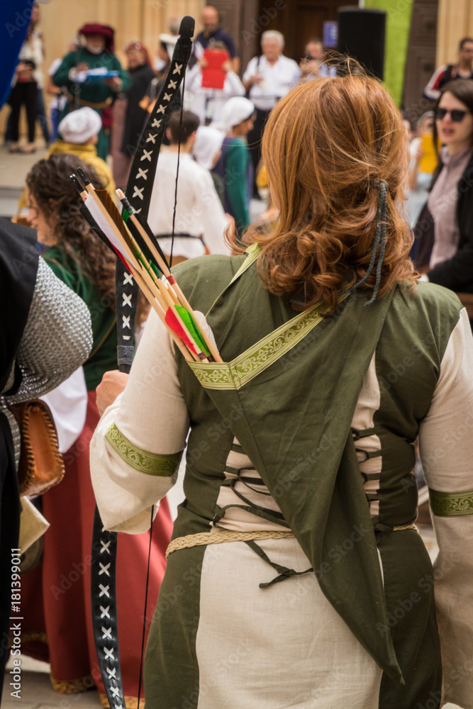 Young female archer dressed in traditional ancient medieval clothing with quiver of arrows and bow, Medieval Mdina, Malta, April 2017