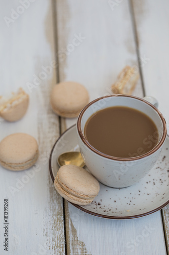 a cup of coffee with pink macaroons