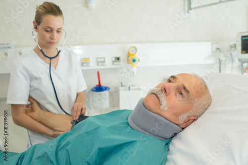 doctor examining senior patient on bed