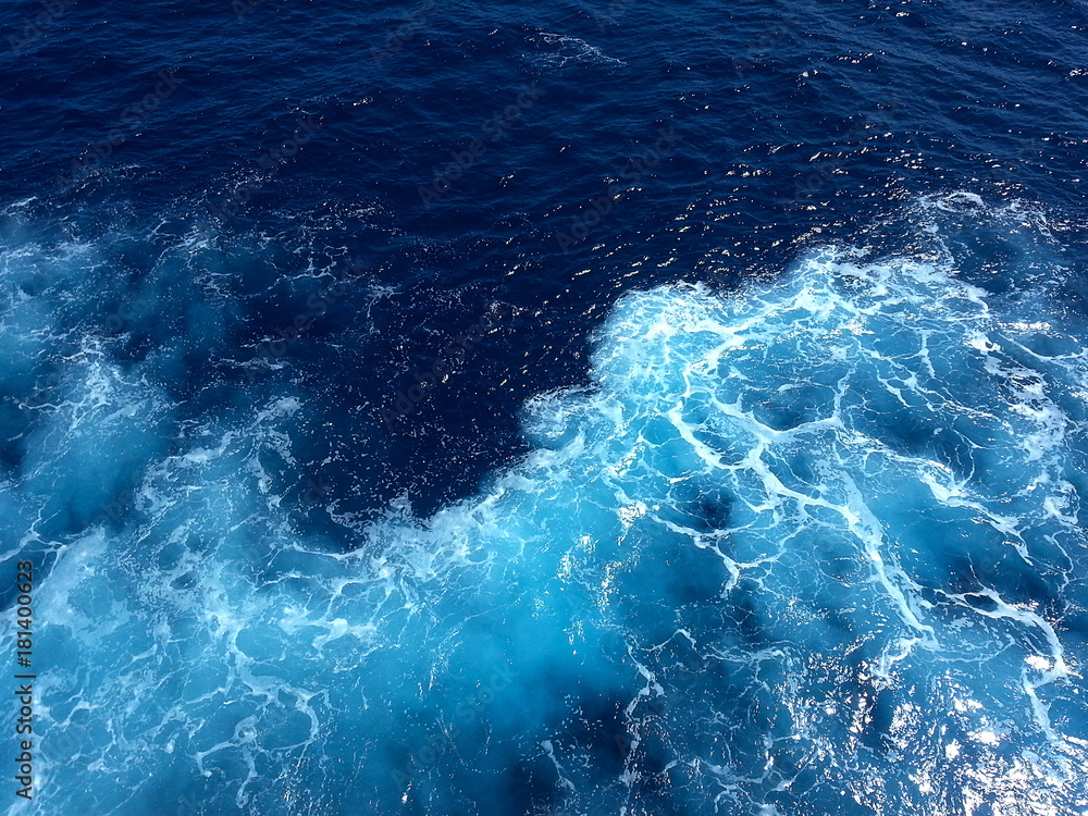 ocean-view seascape landscape with blue sky and sunlight big curly ocean wave splitted by waterline to underwater part with air bubbles