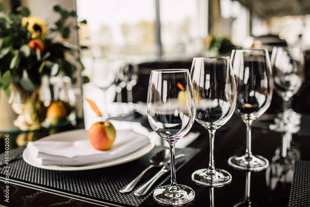 Sparkling glassware stands on long table prepared for wedding dinner Sparkling glassware stands on long table prepared for wedding dinner